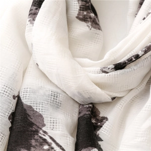 Close-up of linen-feel scarf showing black ink flower prints and slub texture
