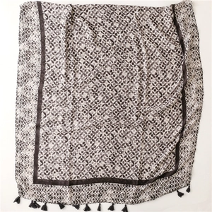 Detailed view of lightweight geometric pattern scarf with stylish black tassels