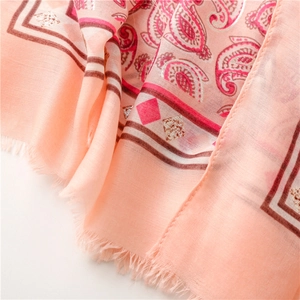 Detail of peach cotton-linen scarf featuring silver paisley print and frayed edges