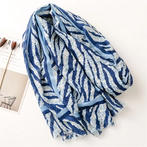 Detailed view of blue zebra print scarf with frayed edges and lightweight fabric texture