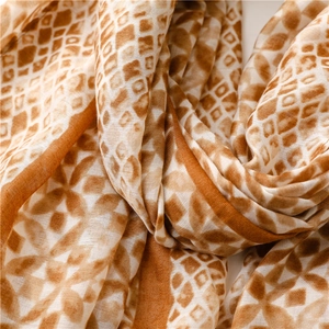 Macro shot of kaleidoscope geometric pattern on a soft satin long silk scarf fabric
