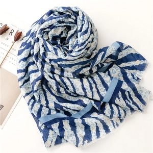 Detail of blue and white zebra-leopard print scarf with soft fringed edges on white background