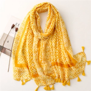 Detail of yellow geometric print scarf with fringed edges and soft cotton texture