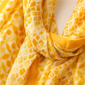 Close-up of lightweight yellow and white geometric kaleidoscope pattern silk scarf