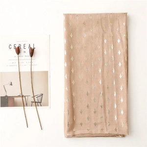 Detail of peach pink gauze scarf with golden diamond foil print and light texture
