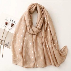 Close-up of soft beige scarf with gold foil diamond pattern and natural texture