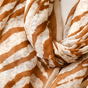 Detailed macro of leopard print scarf featuring shiny silver sequins and soft fabric texture