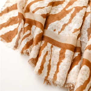 Detailed view of leopard print scarf with silver foil accents and frayed edge texture