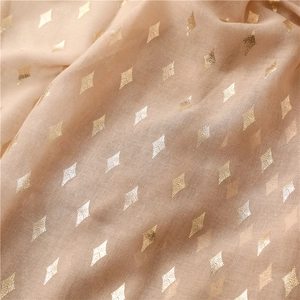Close-up of soft beige cotton scarf featuring metallic gold rhombus pattern and textures