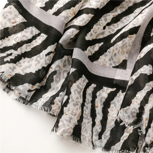 Detail of leopard and zebra print scarf with gold shimmer accents and frayed edges