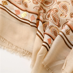 Detailed view of paisley print linen scarf with metallic silver foil and soft tassels
