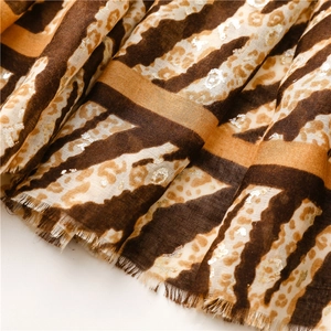 Close-up of leopard animal print scarf with metallic foil accents and frayed edges