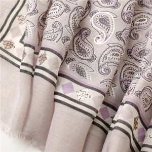 Macro shot of paisley pattern cotton linen scarf with silver foil and fringe trim