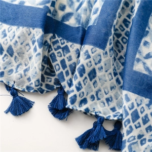 Detail of blue and white kaleidoscope pattern scarf with elegant silk fringe tassels