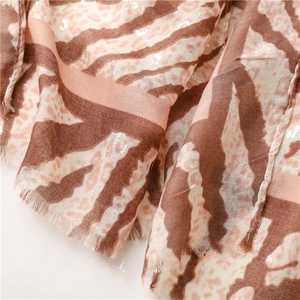Close-up of leopard and zebra print scarf with silver foil accents and frayed edges