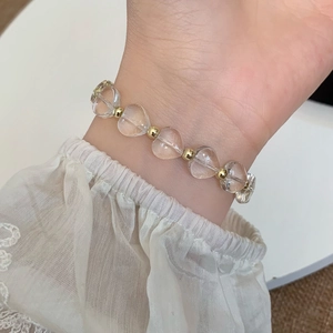 Bracelet élégant avec perles de verre en cœur transparent et touches dorées