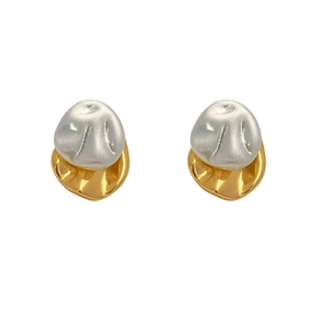 Detail of irregular bicolored earrings with pearl white sphere and gold metal base