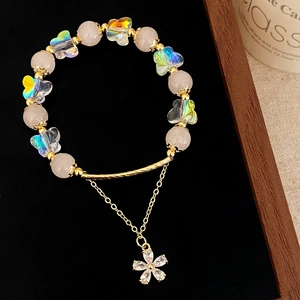 Close-up of pink crystal beads with butterfly charms and a sparkling flower pendant