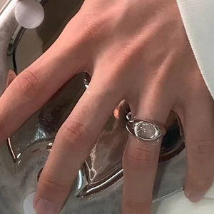 Macro detail of silver ring with oval cat-eye stone and chain textured band