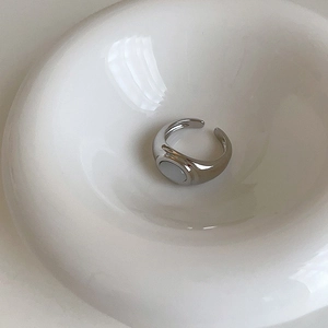 Close-up of a silver adjustable ring with a polished white opal oval gemstone