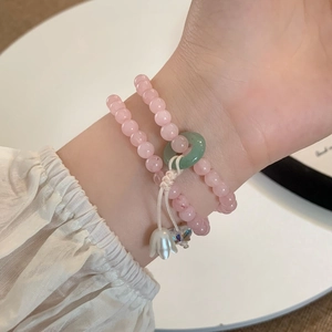 Pink quartz bead bracelet featuring lily of the valley charm and jade ring pendant