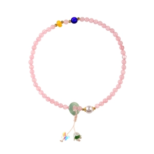 Pink quartz beaded bracelet with pearl, jade ring and lily butterfly charms on white background