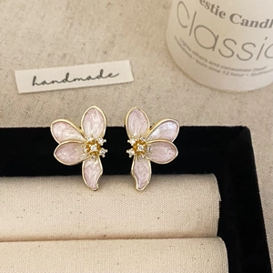 Detail of floral petal earrings with pink enamel and crystals in a jewelry box
