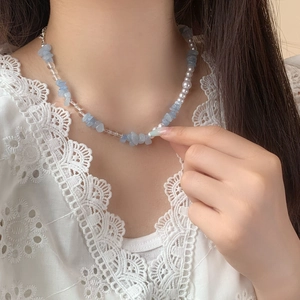 Collier élégant perles bleues et blanches sur fond en dentelle pour femmes chic