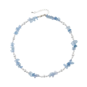 Collier élégant avec pierres bleu clair et perles blanches sur fond blanc neutre
