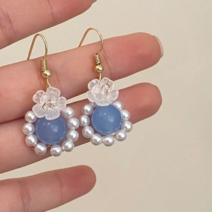 Detail of light blue natural stone earrings with pearl fringe and gold hooks