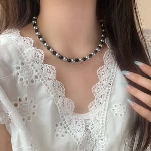 Collier élégant avec perles grises et boules de cristal noires porté au cou