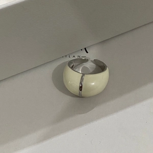 Vue macro d'une bague réglable en argent avec incrustation d'émail ivoire et ligne centrale