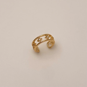 Detailed macro view of gold star ear cuff with double layer镂空 and zircon inlays