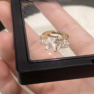 Macro detail of luxury gold-plated ring featuring large emerald cut white gemstone