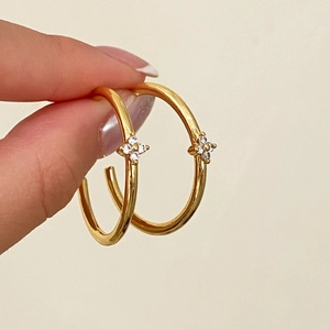 Eleganti orecchini a cerchio dorati con un raffinato ciondolo a fiore in zircone brillante