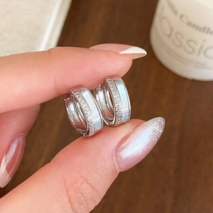 Détail rapproché des boucles d'oreilles en argent avec zircon et insert blanc