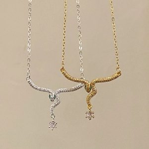 Elegant snake pendant necklace with crystal tassel and green gem eyes in gold and silver