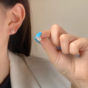 Boucles d'oreilles torsadées argentées minimalistes portées pour un style moderne