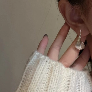 Minimalist silver twist earrings with a sleek streamlined design on a model