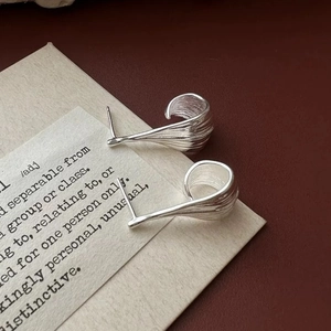 Detail of silver twisted studs with brushed texture on a vintage background