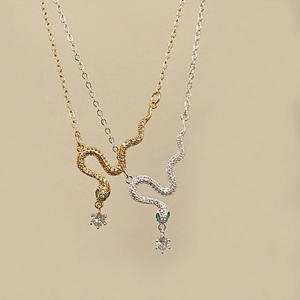 Elegant snake pendant necklace with zircon paving and green gem eyes in gold and silver