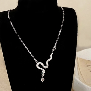 Detailed view of silver snake pendant with zircon pavé and a hanging round crystal