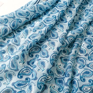 Close-up of light blue cotton scarf featuring silver paisley prints and fine textures