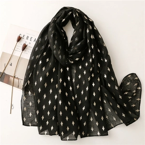 Black lightweight scarf with gold foil diamond patterns on white background with props