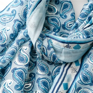 Macro detail of silver paisley patterns on light blue cotton-linen feel scarf
