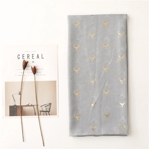 Detail of grey lightweight scarf with gold deer prints and elegant folded texture