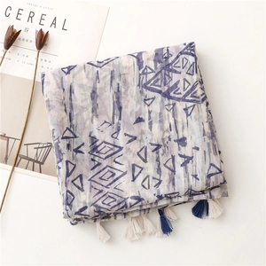 Detail of soft linen-touch scarf featuring purple geometric prints and tassel edges