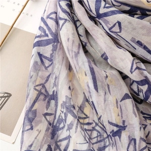 Close-up of cotton linen scarf with abstract blue and yellow geometric prints and tassels