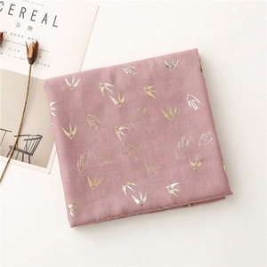 Close-up of pink linen-touch scarf featuring elegant gold and silver swallow patterns