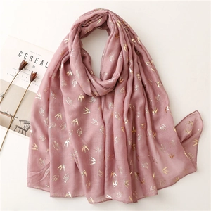 Detail of light pink scarf featuring gold foil swallow prints and light linen texture